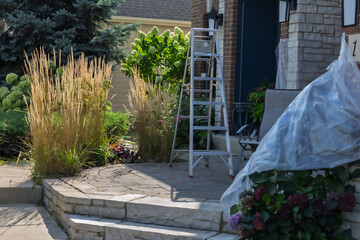 Beautiful and wispy Karl Foerster Feather Reed Grasses, Calamagrostis × acutiflora Karl Foerster, circles the freshly revitalized limestone and paver patio in a residential neighborhood. 