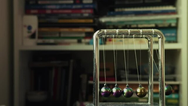 Newtons Cradle and Blurry Books on Shelves