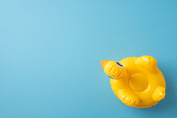 Yellow inflatable duck positioned on a blue backdrop, ideal for summer and fun themes