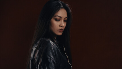 Woman gazing down against a dark background