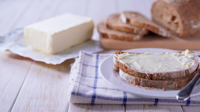Tasty cut multigrain sourdough bread with fresh butter on a white wooden table. slice home baked rye sourdough bread with butter on a wooden table.