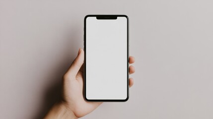 Hand holding smartphone with blank white screen on neutral background