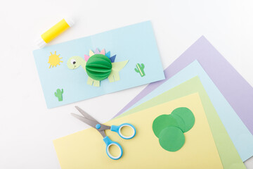Paper cutout of a dinosaur, presented as a whole pastel-colored card from an overhead perspective. Ideal for creative crafts and kids-themed designs,