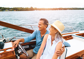 Man, woman and lake adventure with travel in boat on holiday, relax on cruise date for retirement together. Mature, happy couple and driving on water yacht for vacation with happiness, summer in Bali