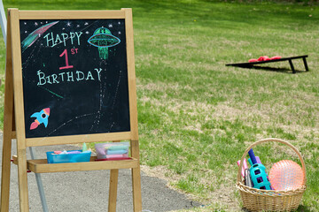 Chalkboard Birthday Sign with UFO Drawing on Grass
