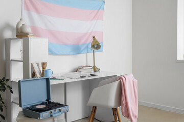 Interior of light room with workplace and transgender flag