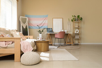 Interior of living room with transgender flag, sofa and workplace