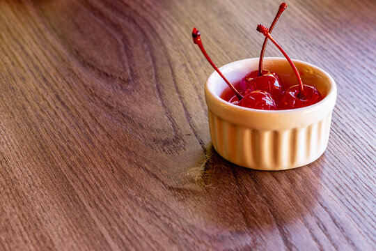 Delicious cherries in bowl on wooden background