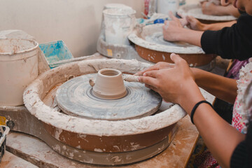 hands of a potter making a bowl spinning 
