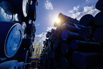 Stack of cast iron pipes in loading area waiting for transportation