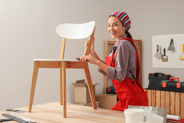 Female decorator putting putty on chair in room