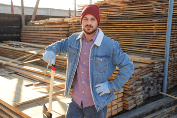 Handsome carpenter with axe at sawmill