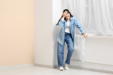 Displeased young woman found mold behind curtain at home