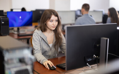 Portrait of female student at computers in university computer class
