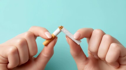 Breaking cigarette hand and broken cigarette held by two hands symbolizing quitting smoking, stop smoking, health, and tobacco