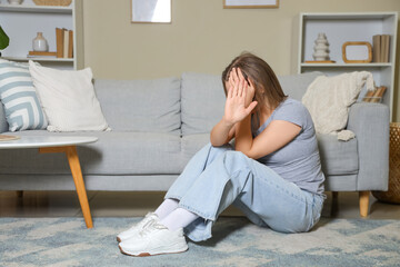 Young woman showing stop gesture at home. Domestic violence concept