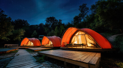 Luxury glamping tents illuminated at night in a forest with cozy wooden decks under starry sky