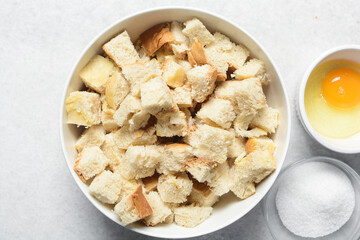 Overhead view of ingredients for making bread pudding, top view of mise en place of ingredients for making bread pudding, process of making bread pudding