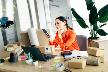 Young female entrepreneur managing ecommerce orders in a stylish workspace