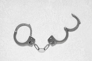 Police officer's handcuffs on light background