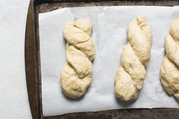 Overhead view of homemade pretzels dough on a baking tray, top view of freshly boiled soft pretzel dough on a white background