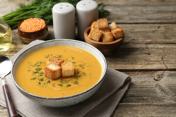 Delicious lentil cream soup served on wooden table