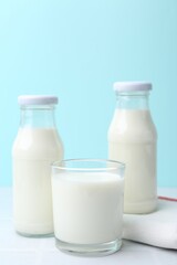 Fresh milk on white table against light blue background