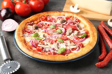 Tasty pizza with smoked sausages, ingredients and cutter on gray textured table, closeup