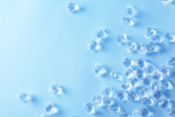 Cubes of clear ice on light blue background, flat lay. Space for text