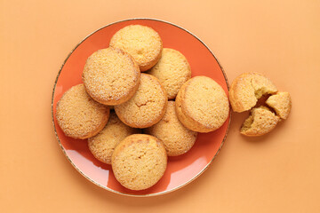 Plate with sweet cookies on brown background