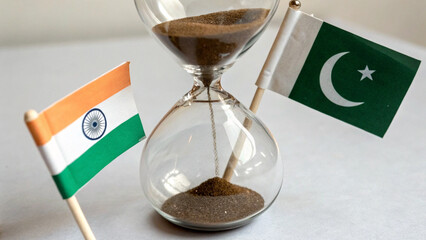 An hourglass where sand flows with Indian and Pakistani flags at opposite ends, symbolizing decades of tension, AI