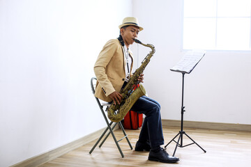 Portrait Of Young Asian Saxophonist Man In Formal Suit Plays Jazz Music On Saxophone