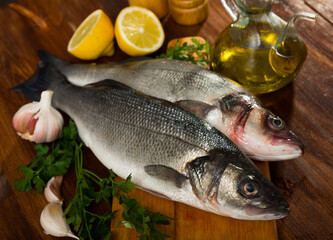 Raw sea bass with lemon, garlic and parsley on cutting board