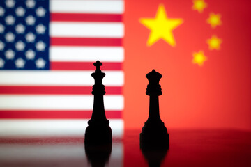 Silhouettes of chess kings against US and China flags, symbolizing economic tension, tariffs, and...