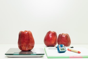 an apple on a digital balance in the laboratory, food safety concept