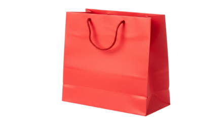 A single red paper shopping bag with rope handles isolated on a black background in a studio shot