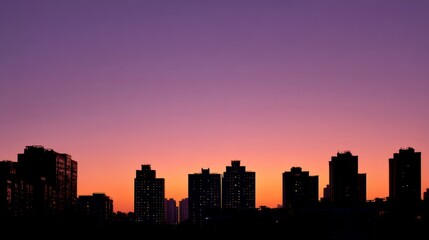 City skyline silhouette against a warm dusk sky, urban simplicity meets serene twilight.
