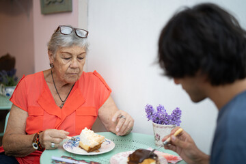 Grandmother and grandson enjoying dessert at a cafe