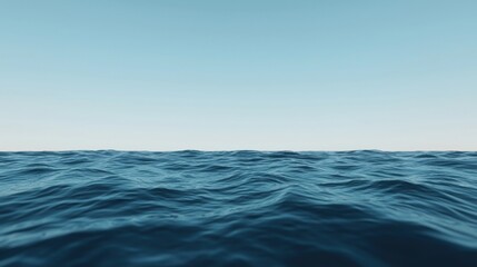 Calm ocean waves stretch to the horizon under a clear blue sky.
