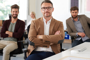 Fototapeta premium Businessman, arms crossed and portrait with smile in office for career confidence, startup pride or coworking job. Professional, designer or happy at advertising agency for project management at desk