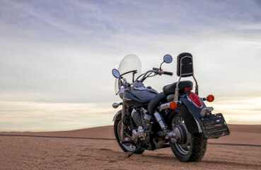 Off-road motorcycle parked in the desert under dramatic cloudy sky — adventure, travel, freedom, and extreme outdoor landscape concept