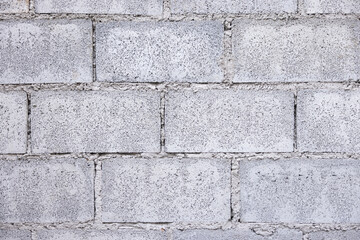 Fototapeta premium Concrete block wall background consist of rough surface of texture cement and gravel. Pattern of rectangle shape masonry in stacked row horizontal in construction building work. Suit for background.
