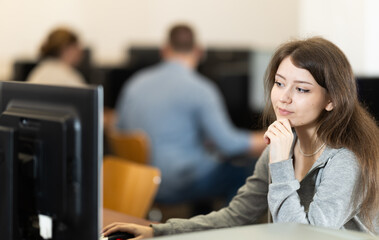 Obraz premium Portrait of young female student studying in university computer class