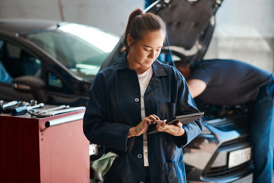 Workshop, woman or car mechanic with digital tablet, maintenance and search with confidence. Repair shop, female expert and technology for motor inspection, ecommerce and typing to order parts online