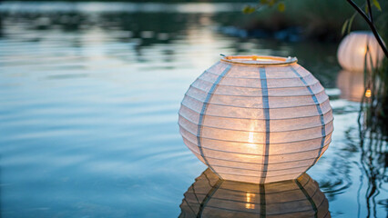 Fototapeta premium Eco-Friendly concept. Illuminated lantern floating on water's surface at dusk.