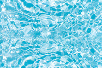 Obraz premium Blue water with ripples on the surface. Defocus blurred transparent blue colored clear calm water surface texture with splashes and bubbles. Water waves with shining pattern texture background.