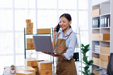 Startup SME small business entrepreneur woman SME or freelance Asian woman calling phone, online marketing packaging box and delivery, SME concept
