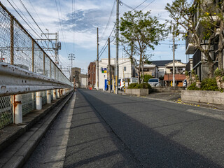 Fototapeta premium 夕暮れ時の線路沿いの道路 