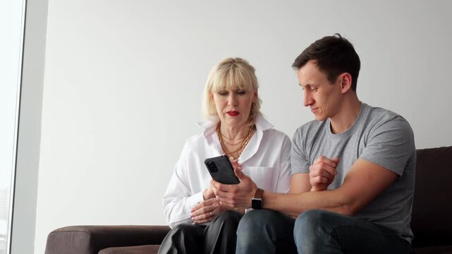 Senior woman learning smartphone usage from young man