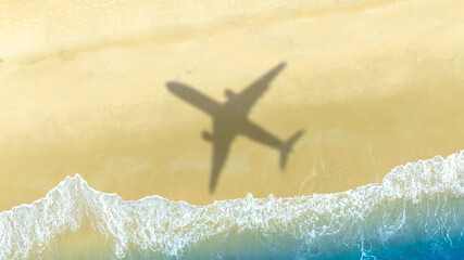 Aerial view of shadow passenger plane silhouette and sandy beach blue sea with waves at sea beach summer vacation sea travel concept	
